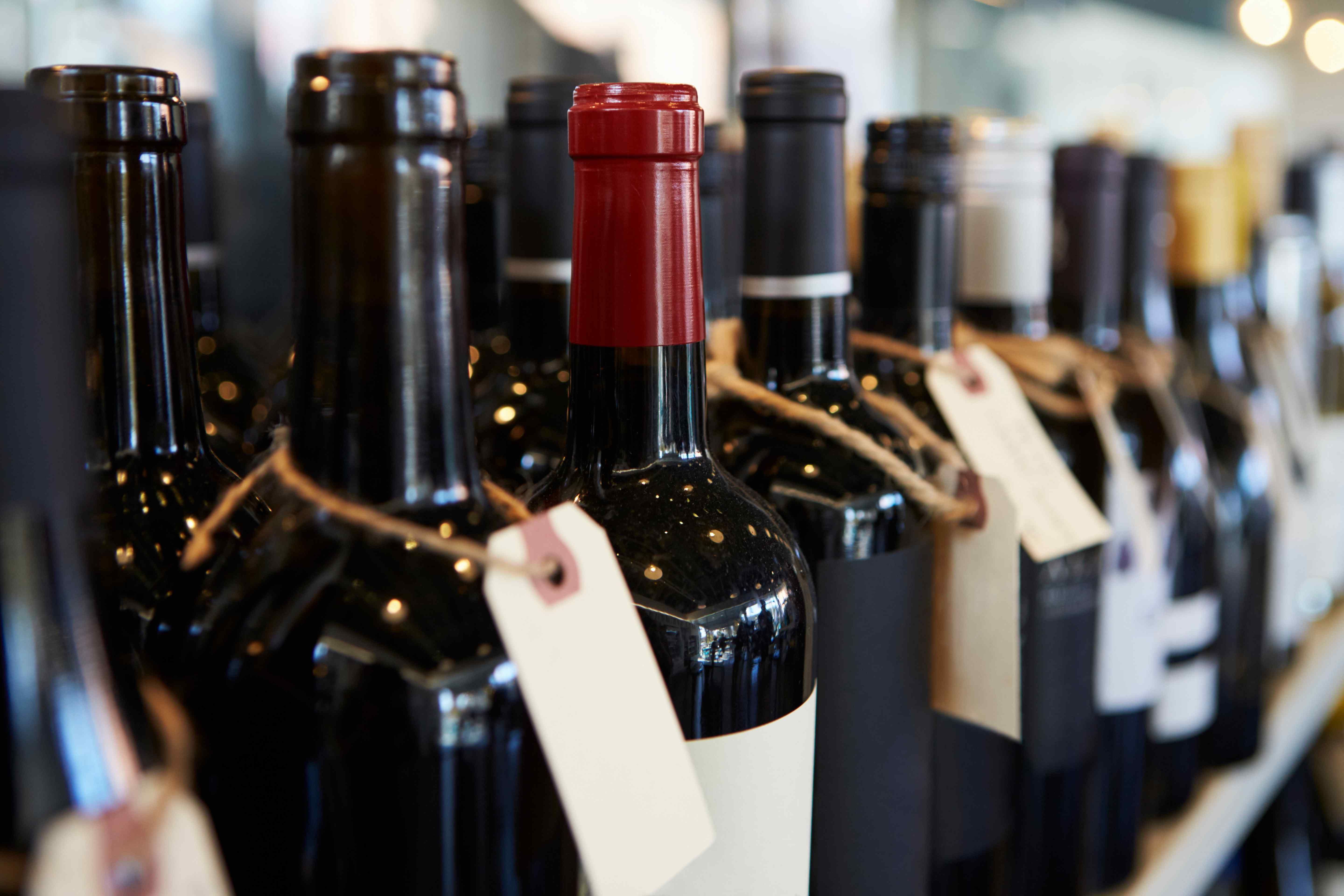 A row of wine bottles with price tags attached, representing wine market valuation.