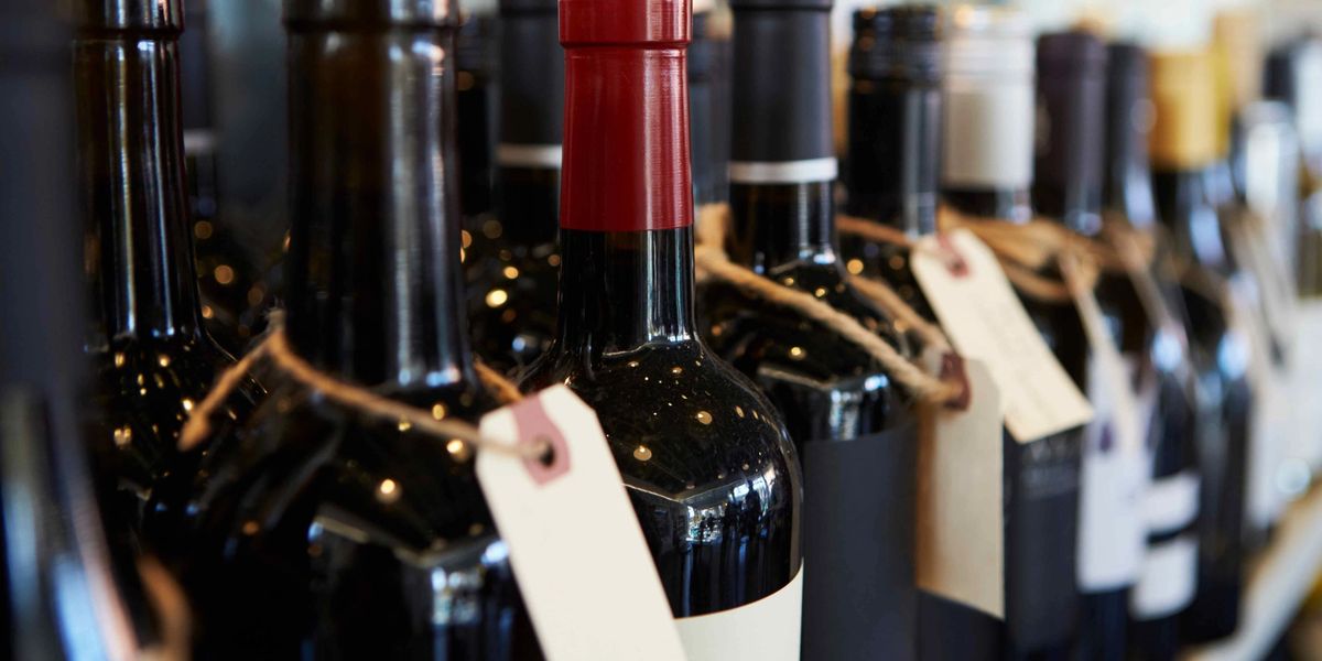 A row of wine bottles with price tags attached, representing wine market valuation.