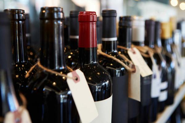 A row of wine bottles with price tags attached, representing wine market valuation.