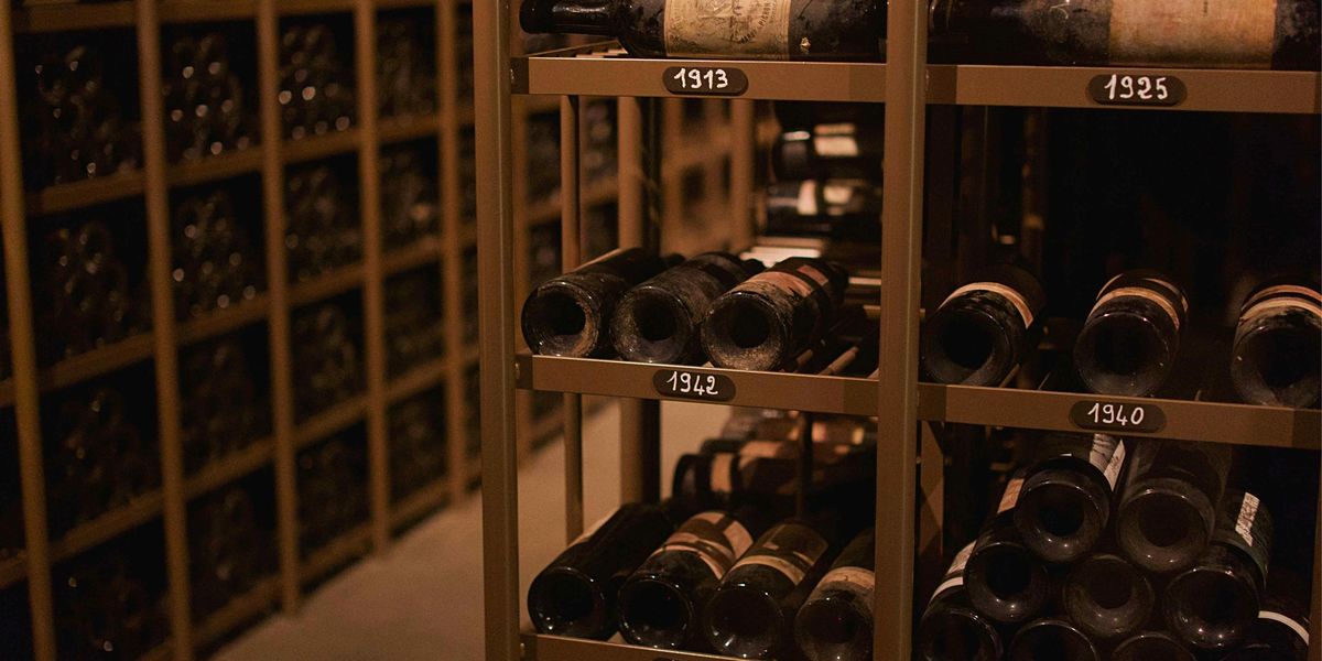 Professional wine cellar racking with vintage-labeled shelves from 1908 to 1945 holding dusty aged bottles.