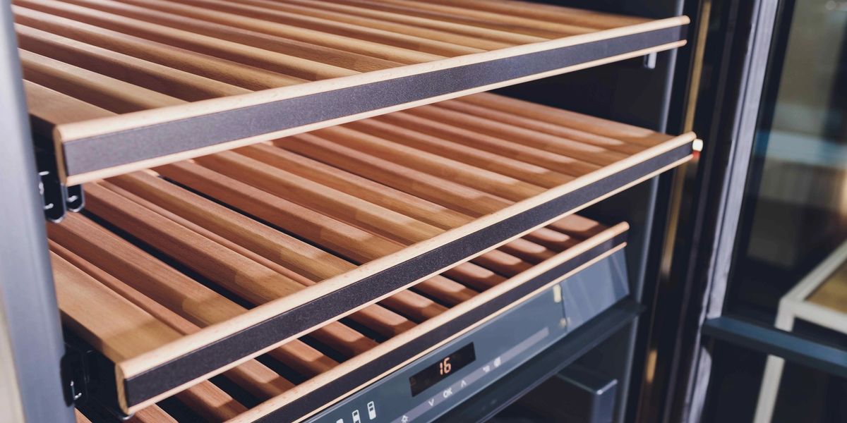 Open wine fridge shelf with wooden slats and a digital control panel displaying 16 degrees.