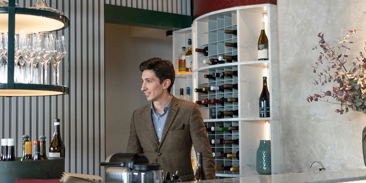A sommelier behind the bar at a restaurant.
