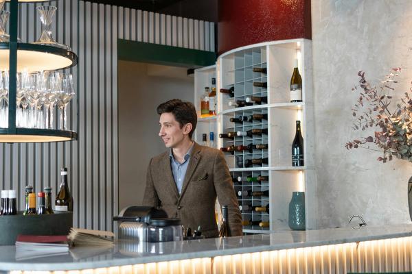 A sommelier behind the bar at a restaurant.