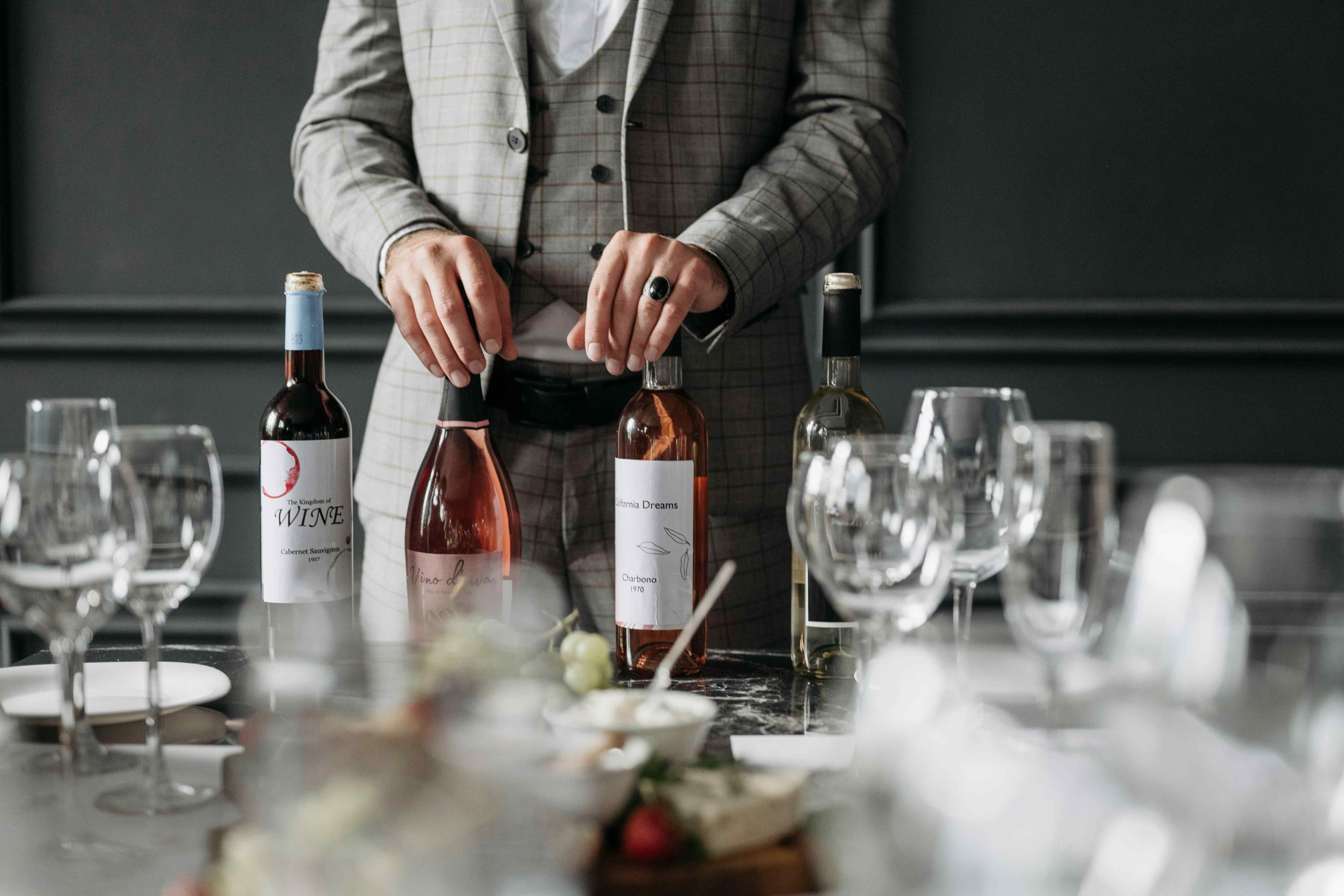 Wine bottles displayed on a table set with glasses at a formal tasting.