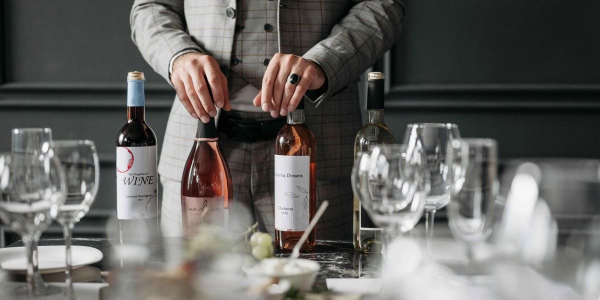 Wine bottles displayed on a table set with glasses at a formal tasting.