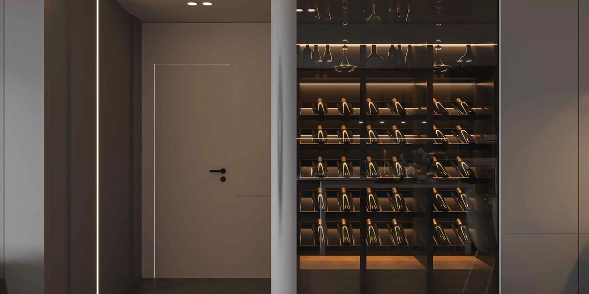 Modern glass-enclosed home wine cellar with backlit shelving and angled bottle racks beside a hallway.