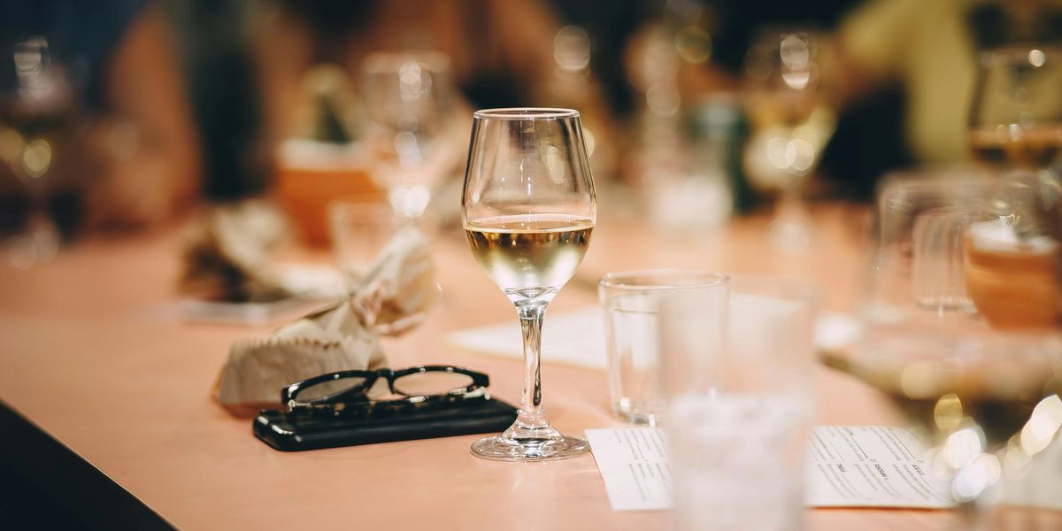 Wine glasses, water glasses, and other miscellaneous items fill a table at a restaurant.