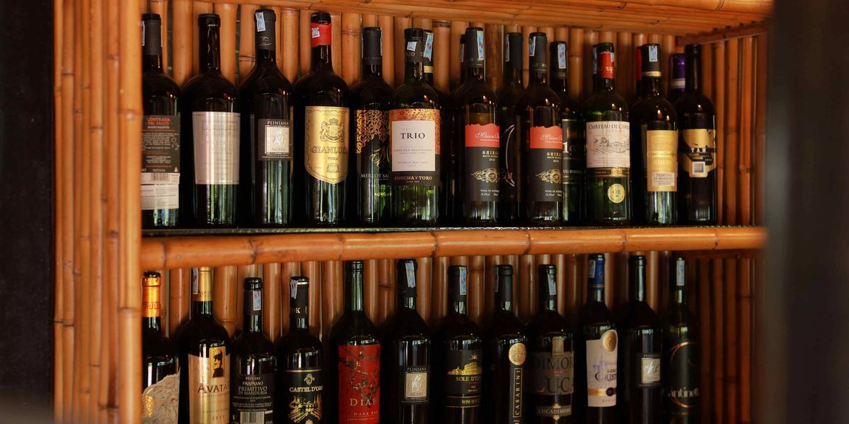 Two shelves full of wine bottles in a wine cellar.