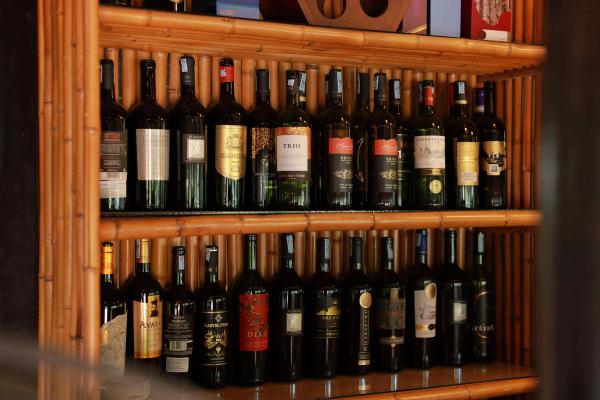 Two shelves full of wine bottles in a wine cellar.