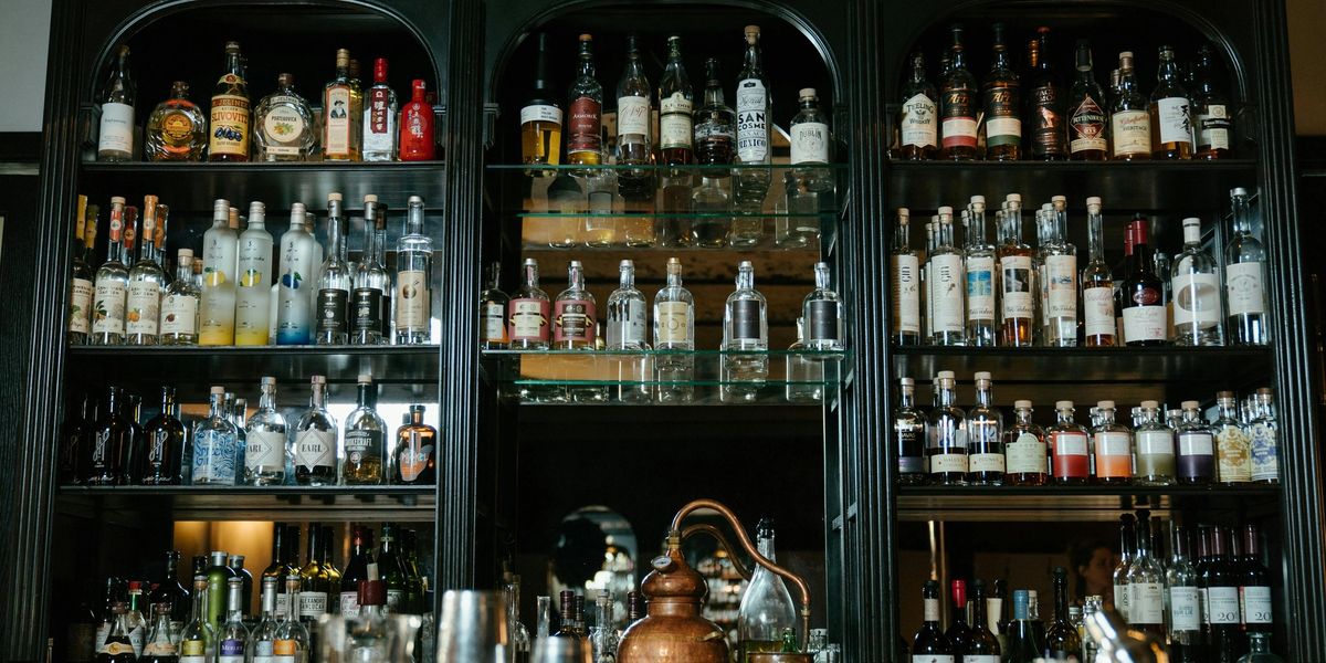Display shelves behind a restaurant's bar, full of wine and liquor bottles.