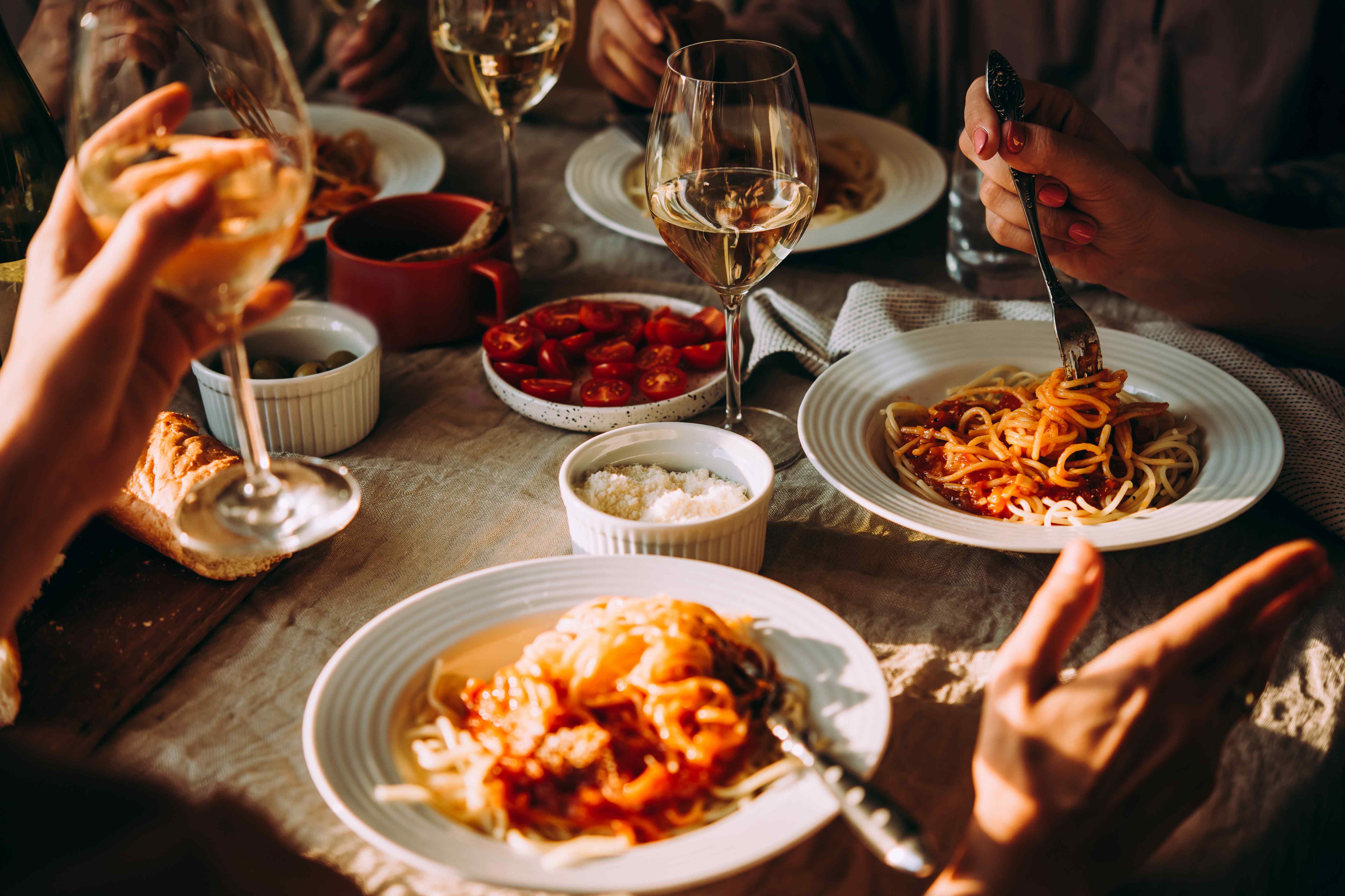 A bustling table full of Italian dishes and full wine glasses.