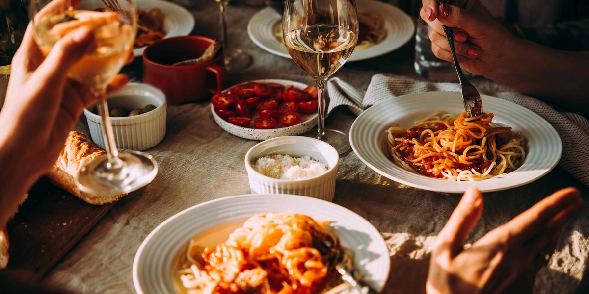 A bustling table full of Italian dishes and full wine glasses.