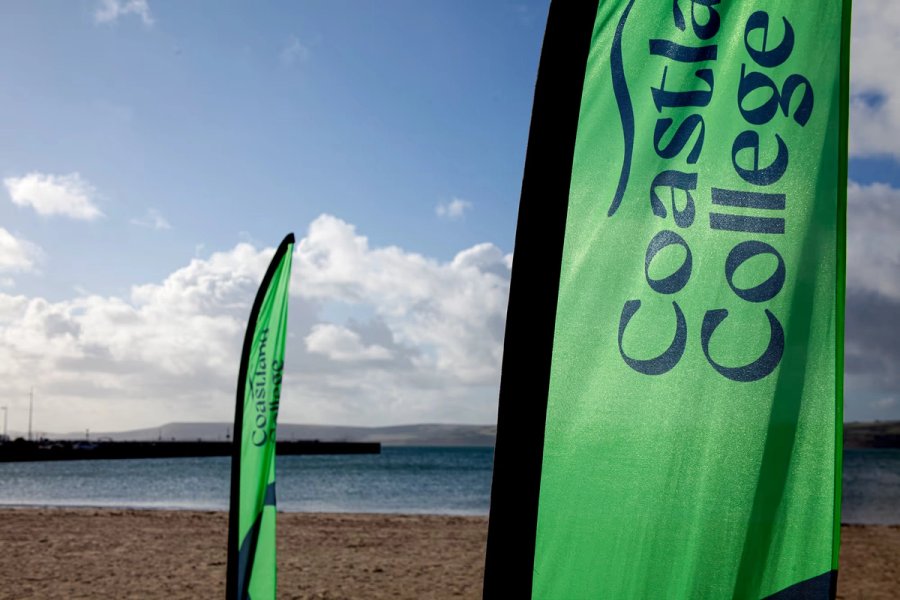 A Coastland College flag on the beach