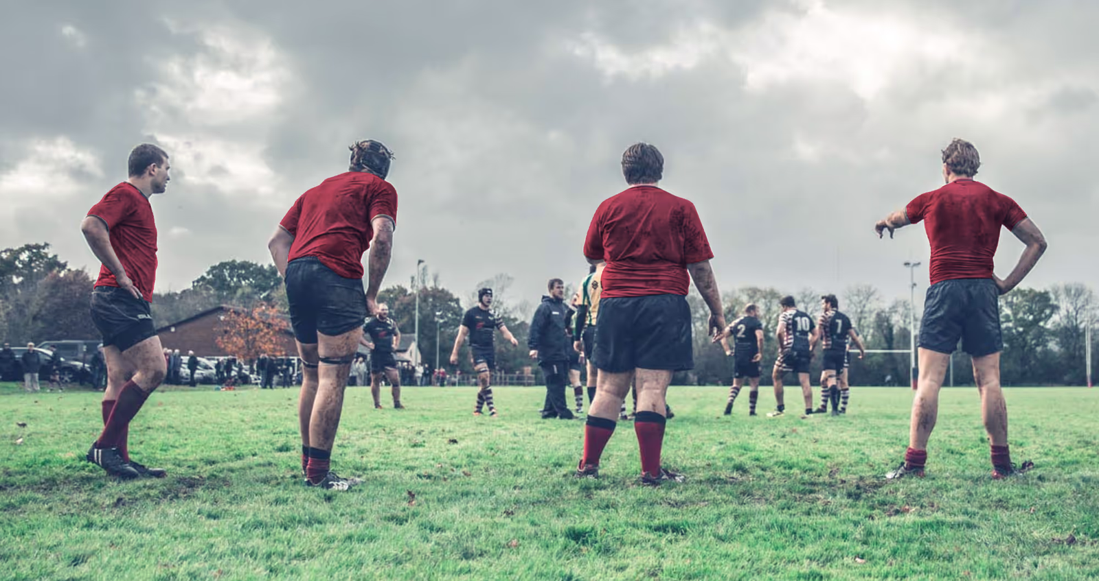4 Men stood in a line playing rugby