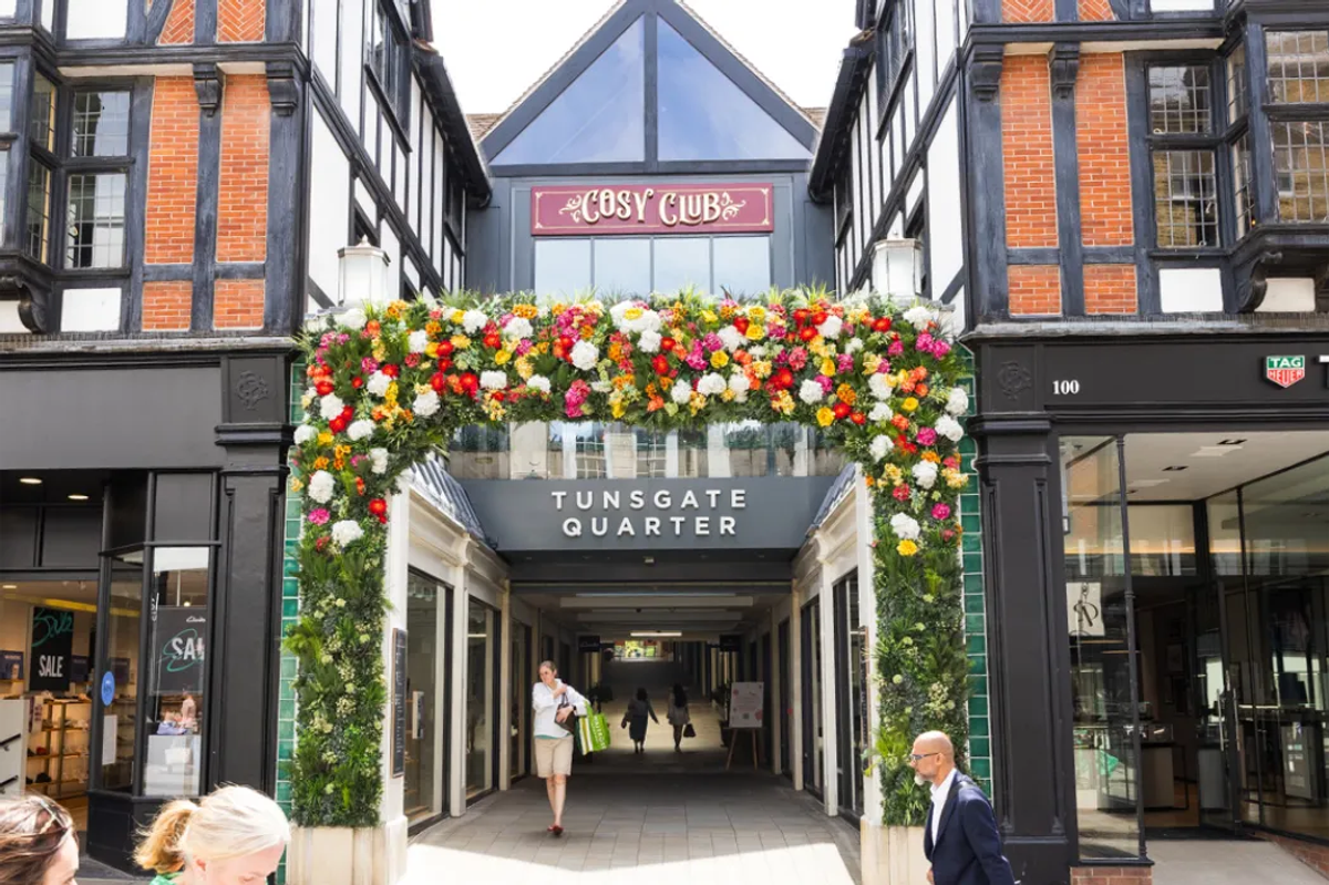 The Tunsgate Quarter building in Guildford High Street with people walking in and out of the entrance.