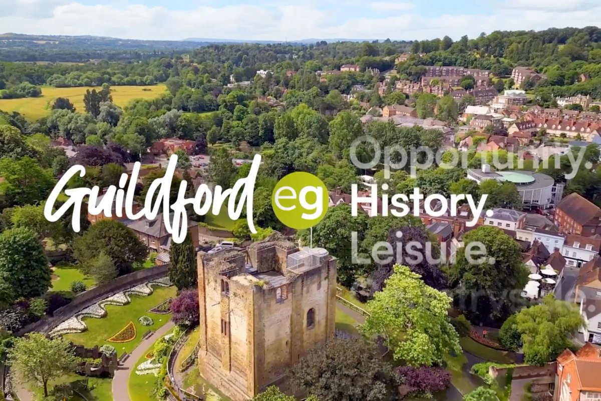 Aerial view of Guildfords historical areas with the Experience Guildford logo and words related to Guildford overlayed.