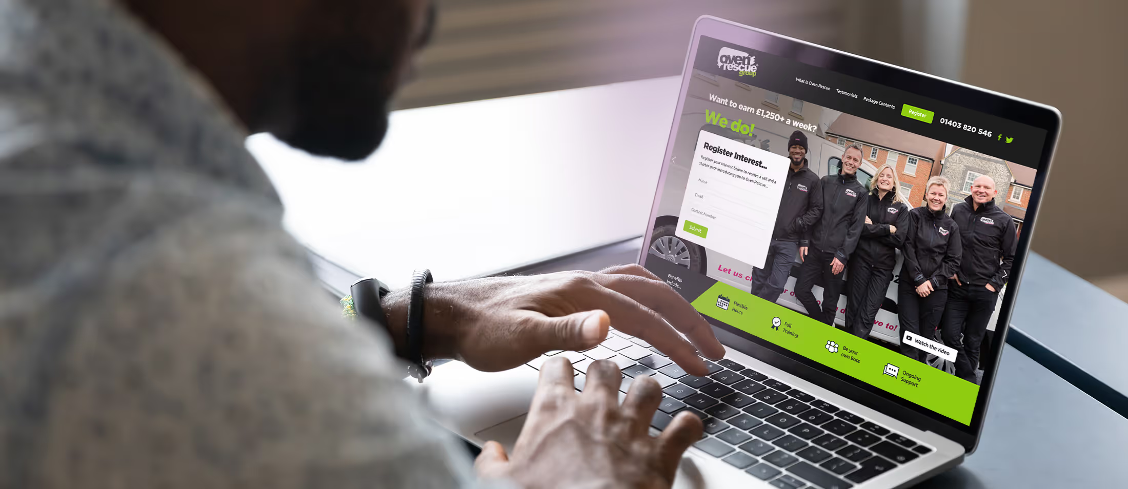 A man using a laptop with the Oven Rescue website on the screen