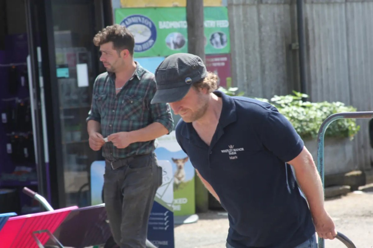 Mark in a Whipley Manor Farm polo shirt works with a trolley while another staff member stands nearby at the farm shop.