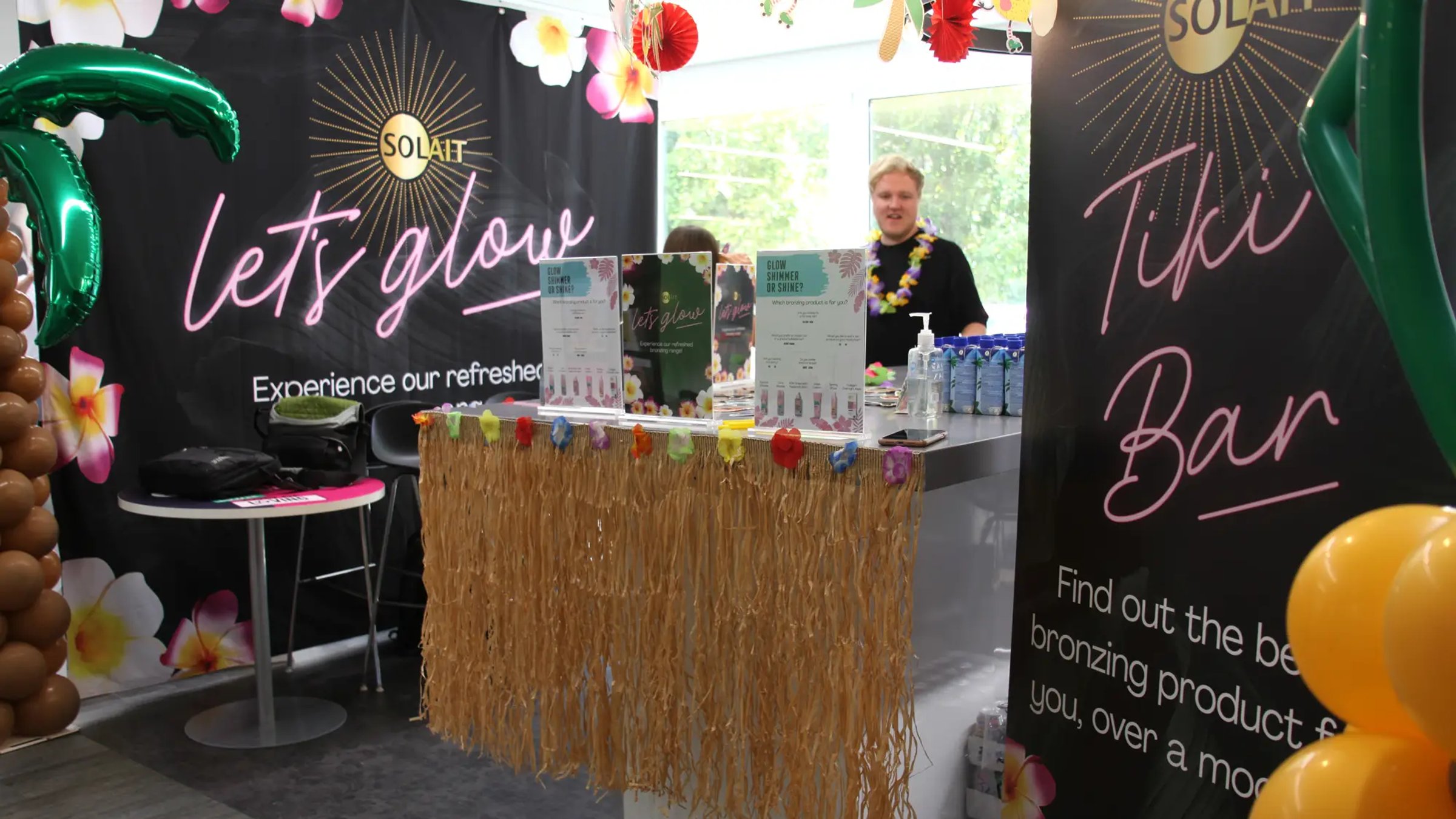 Solait presentation stall with products, wall graphics and tropical decoration all around