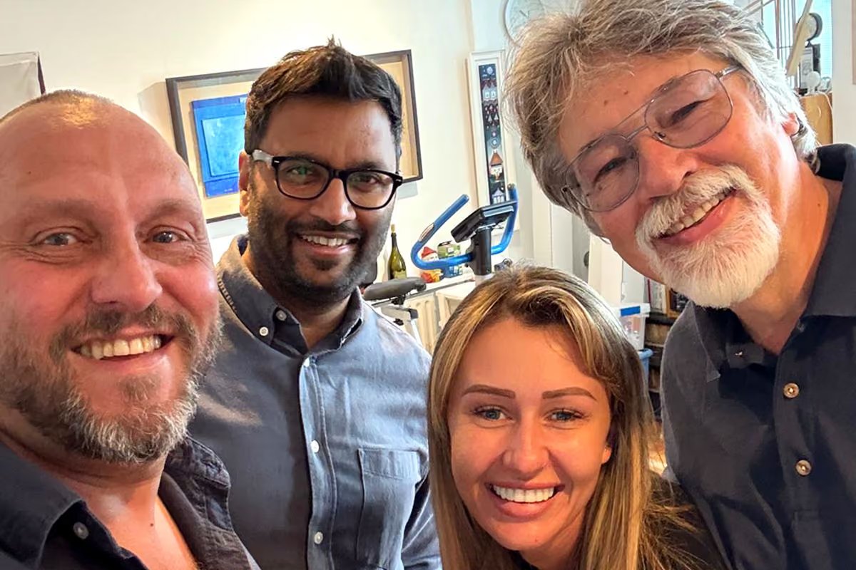 Group selfie of Alex Brychta with three members of the project team, smiling together in his studio