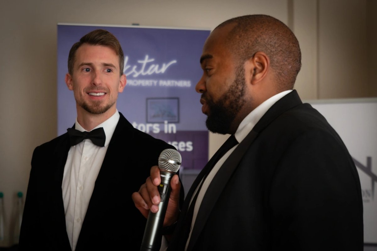 Kane Andrews and a speaker at an event