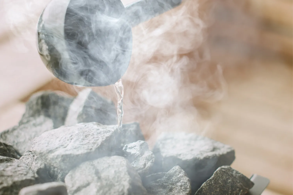 Water poured over hot sauna stones, creating rising steam