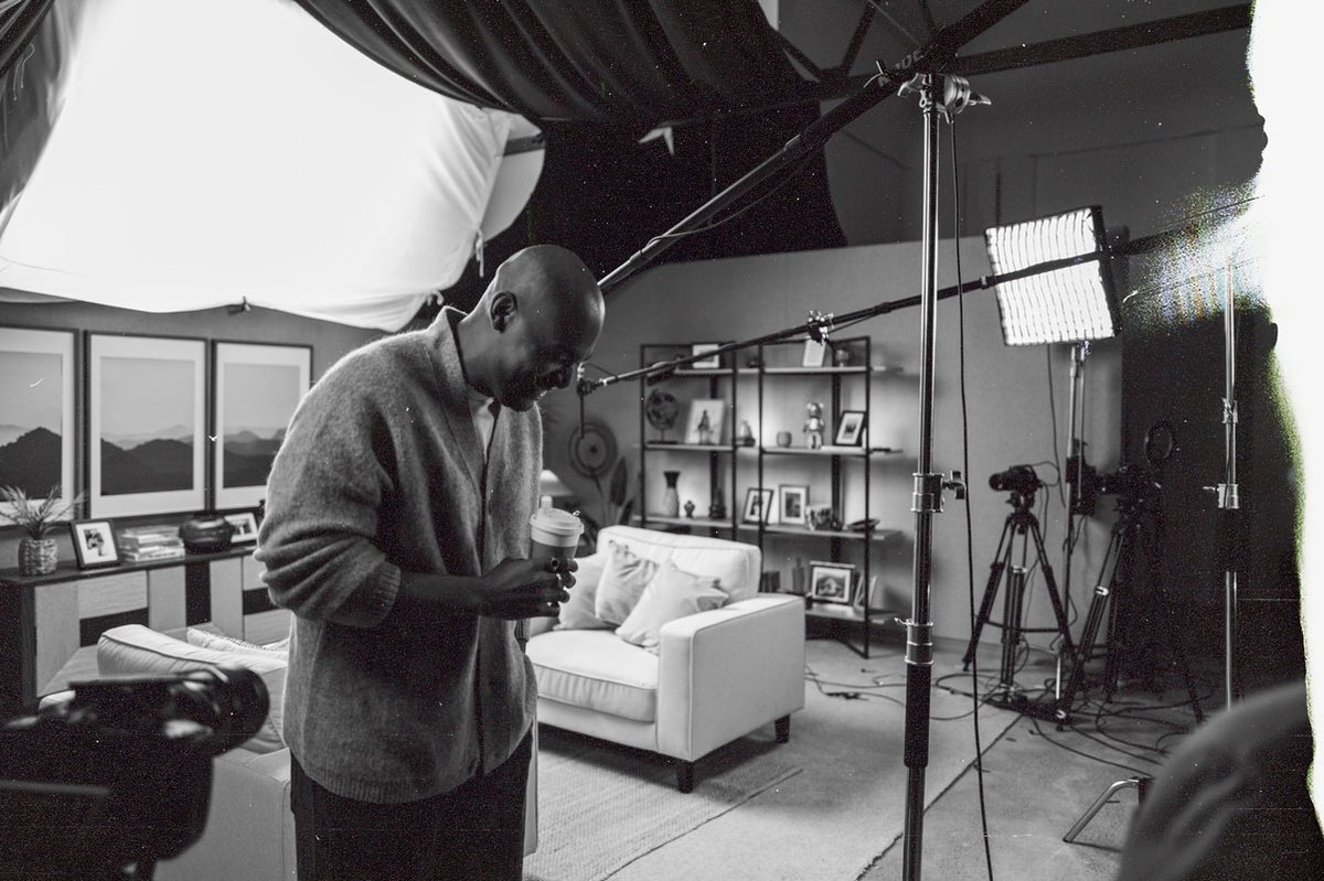 A candid shot of a man in a studio with lighting rigs and microphones visible