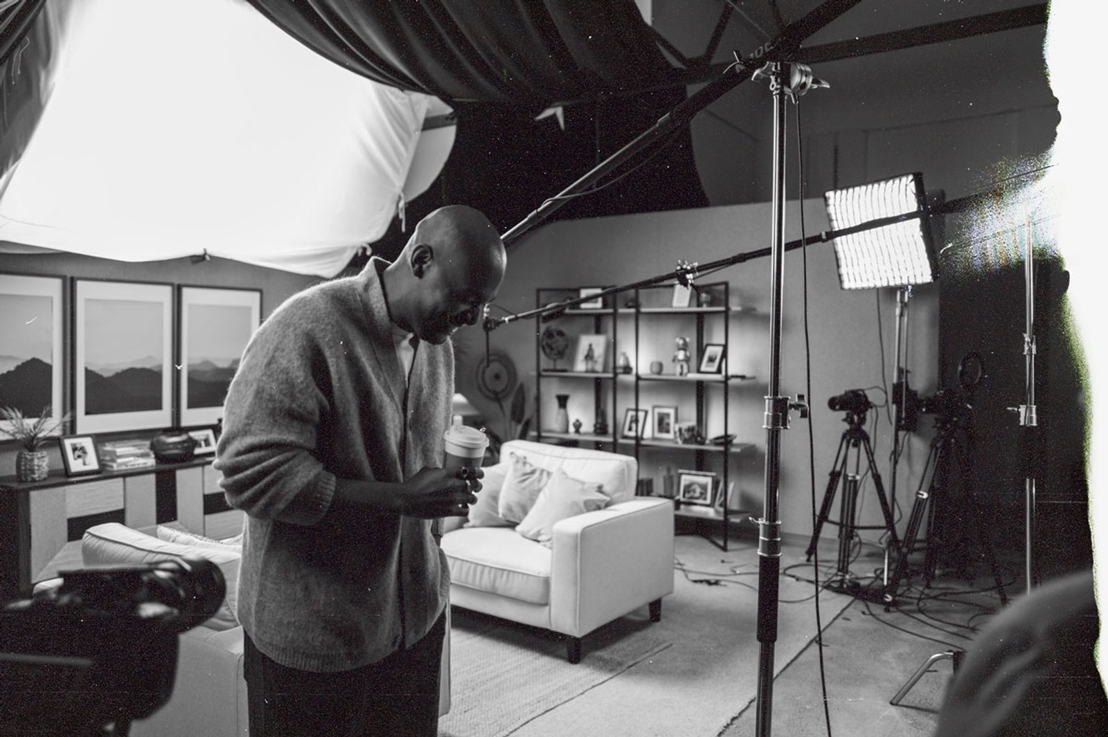 A candid shot of a man in a studio with lighting rigs and microphones visible