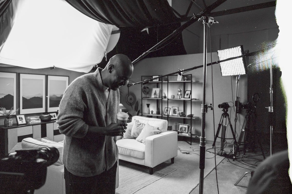 A candid shot of a man in a studio with lighting rigs and microphones visible