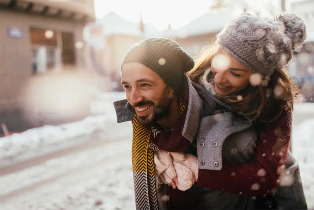 A happy man giving a piggy back to a woman