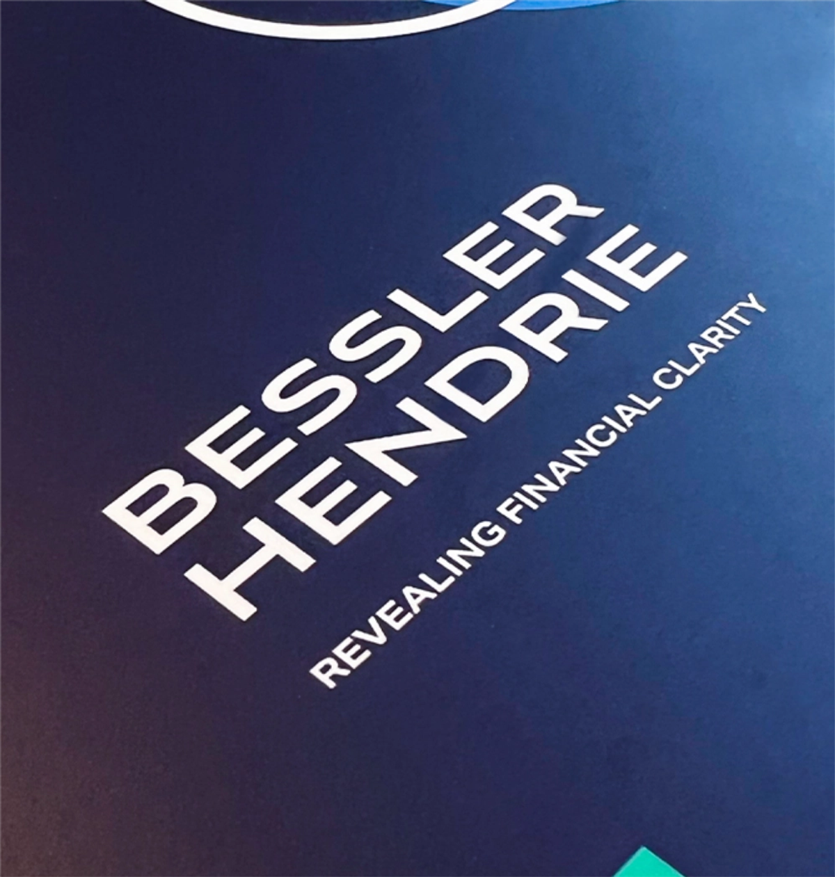 A close-up of the Bessler Hendrie logo and 'Revealing financial clarity' tagline in white on a dark navy background