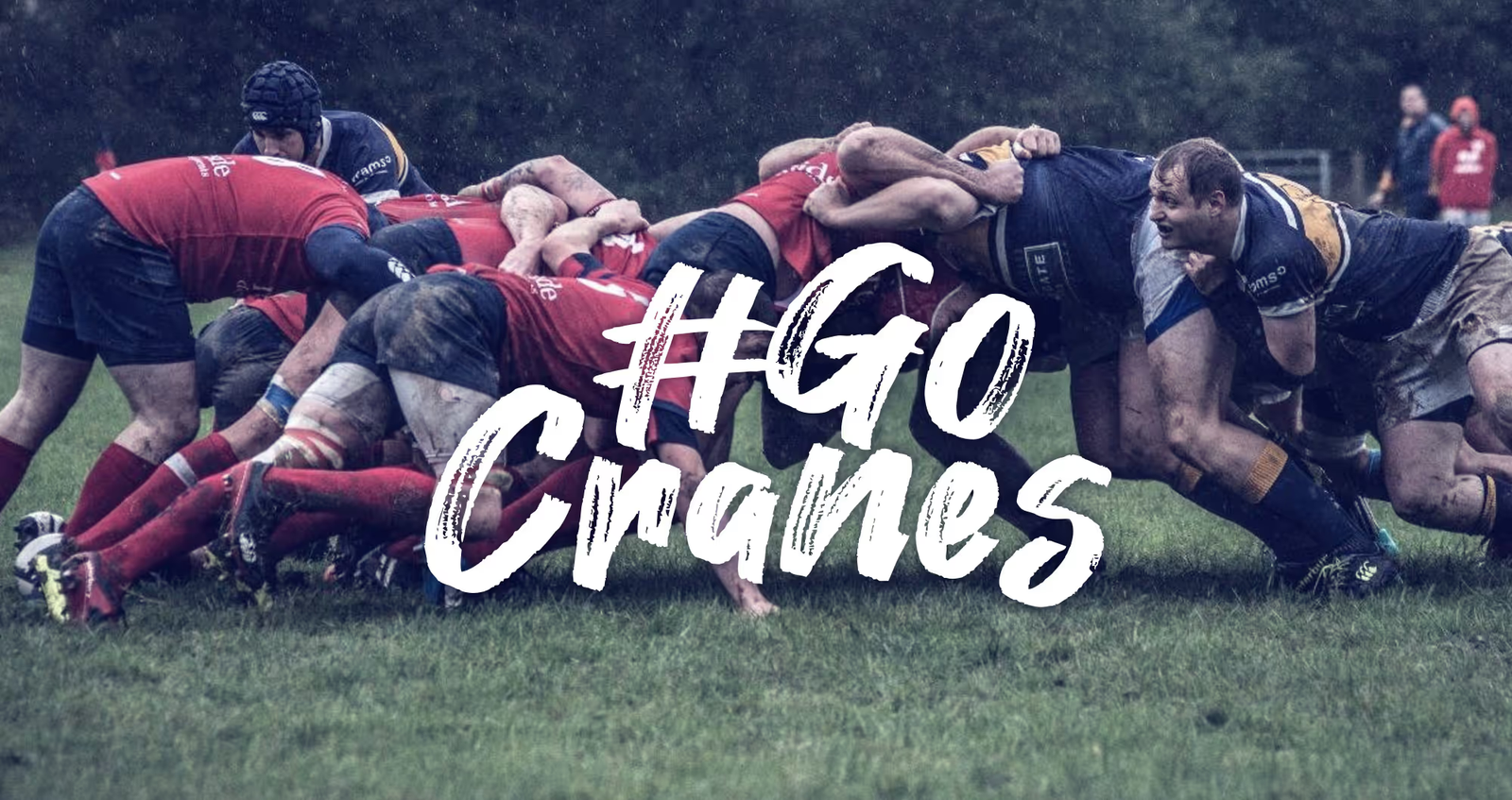 A rugby scrum with the words #gocranes in the foreground