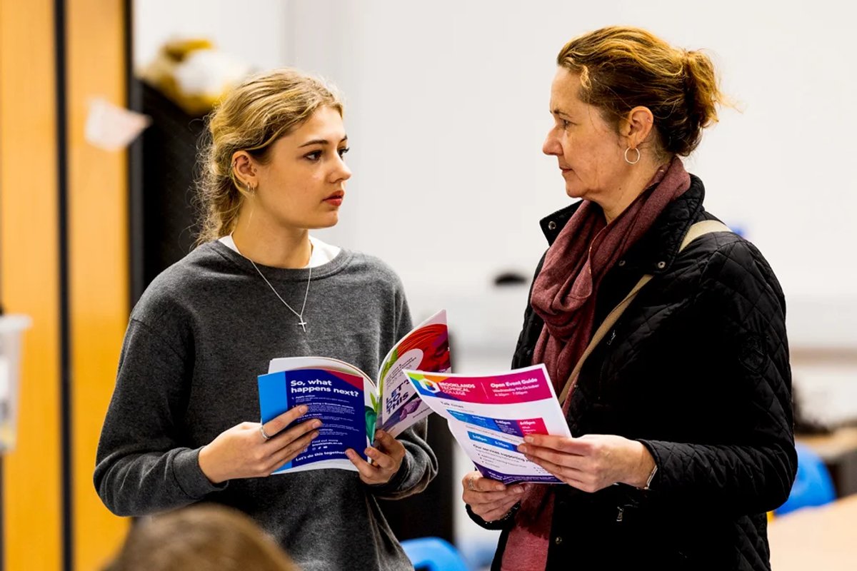 A student and teacher reading the Brooklands prospectus