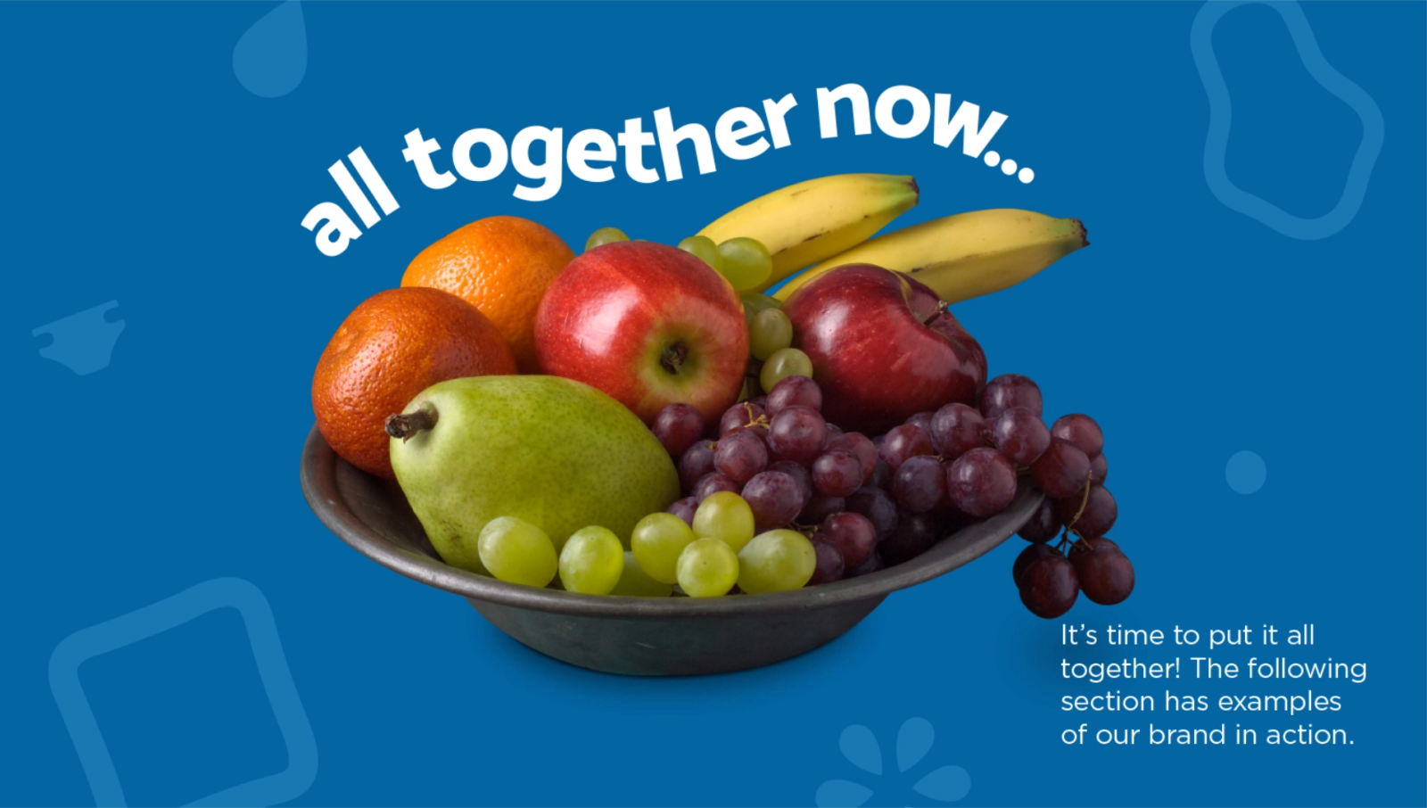 A bowl of mixed fruit including apples, an orange, a pear, bananas and grapes, with the text 'all together now' above it on a blue background