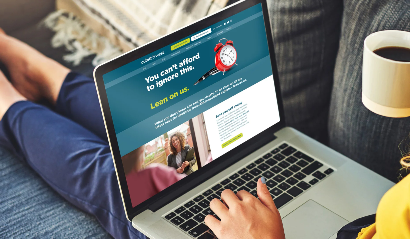 A person using a laptop showing the Cubitt & West website with the headline 'You can't afford to ignore this' about landlord regulations