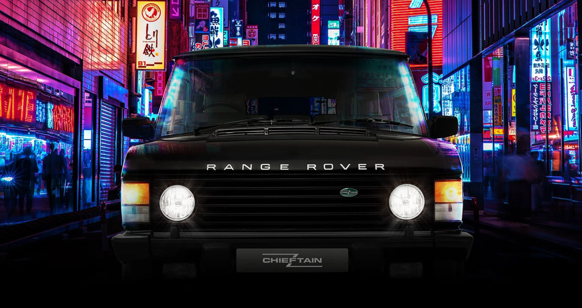 The front of a black Range Rover Chieftain parked in a neon-lit Tokyo street at night