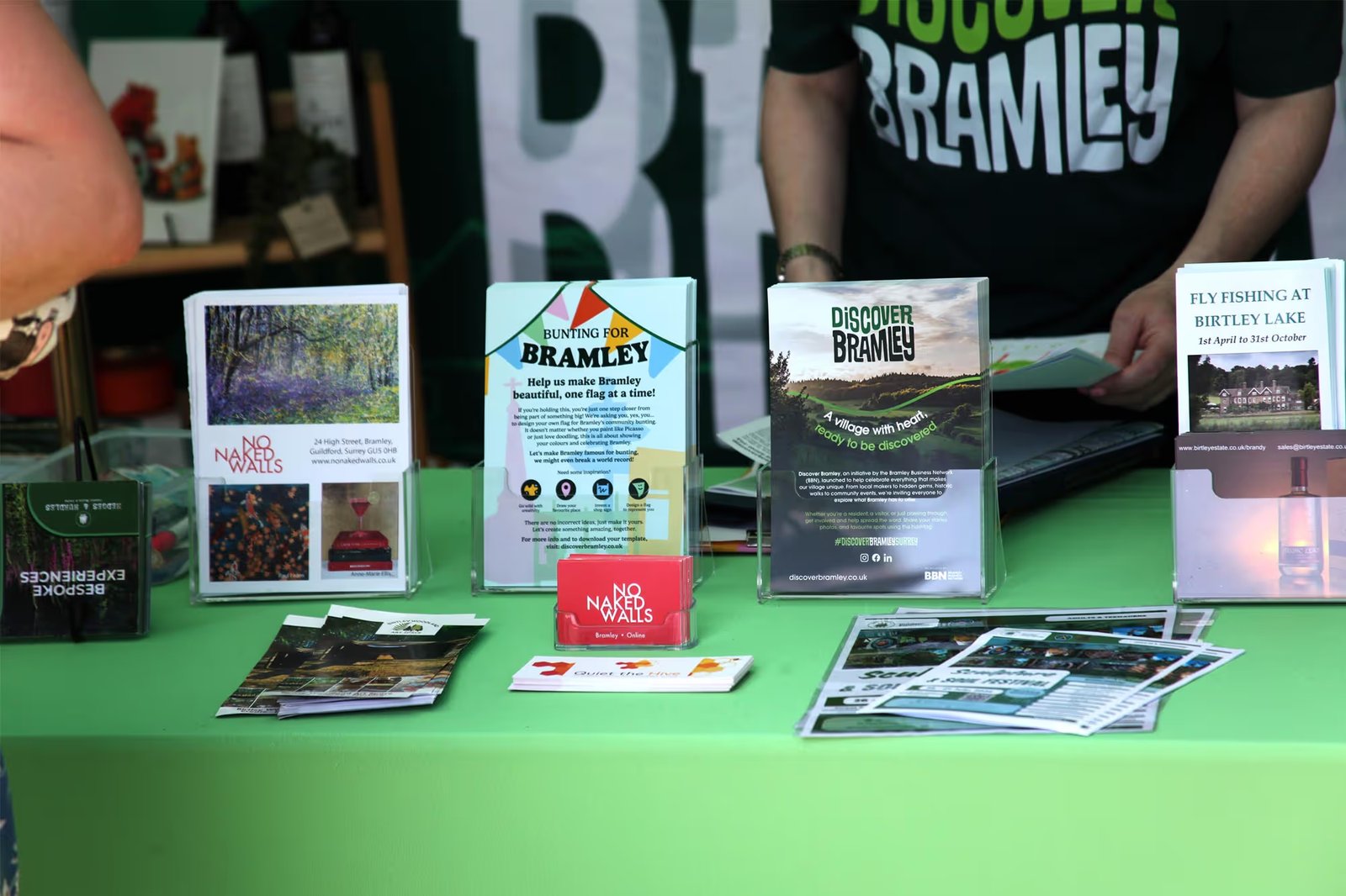 Discover Bramley promotional leaflets and merchandise displayed on a table at a print/marketing fete stall, including a 'Bunting for Bramley' flyer and village brochure