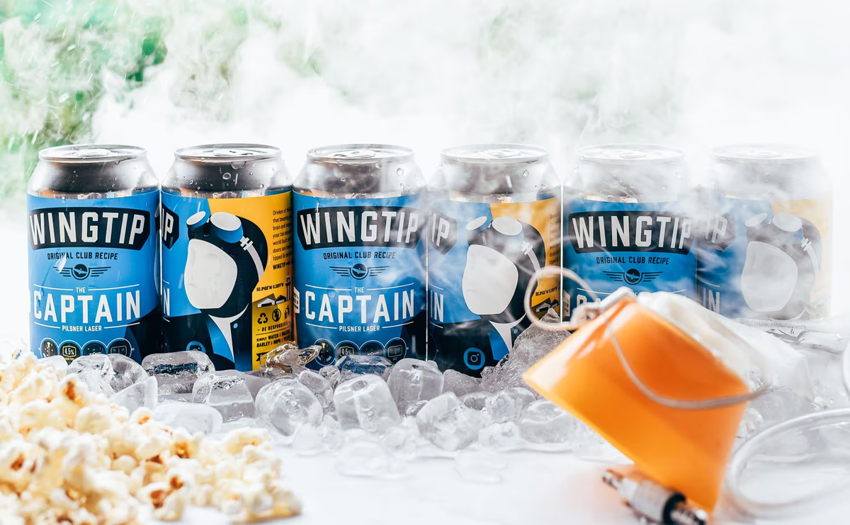 Wingtip Brewery cans in a line surrounded by ice and steam