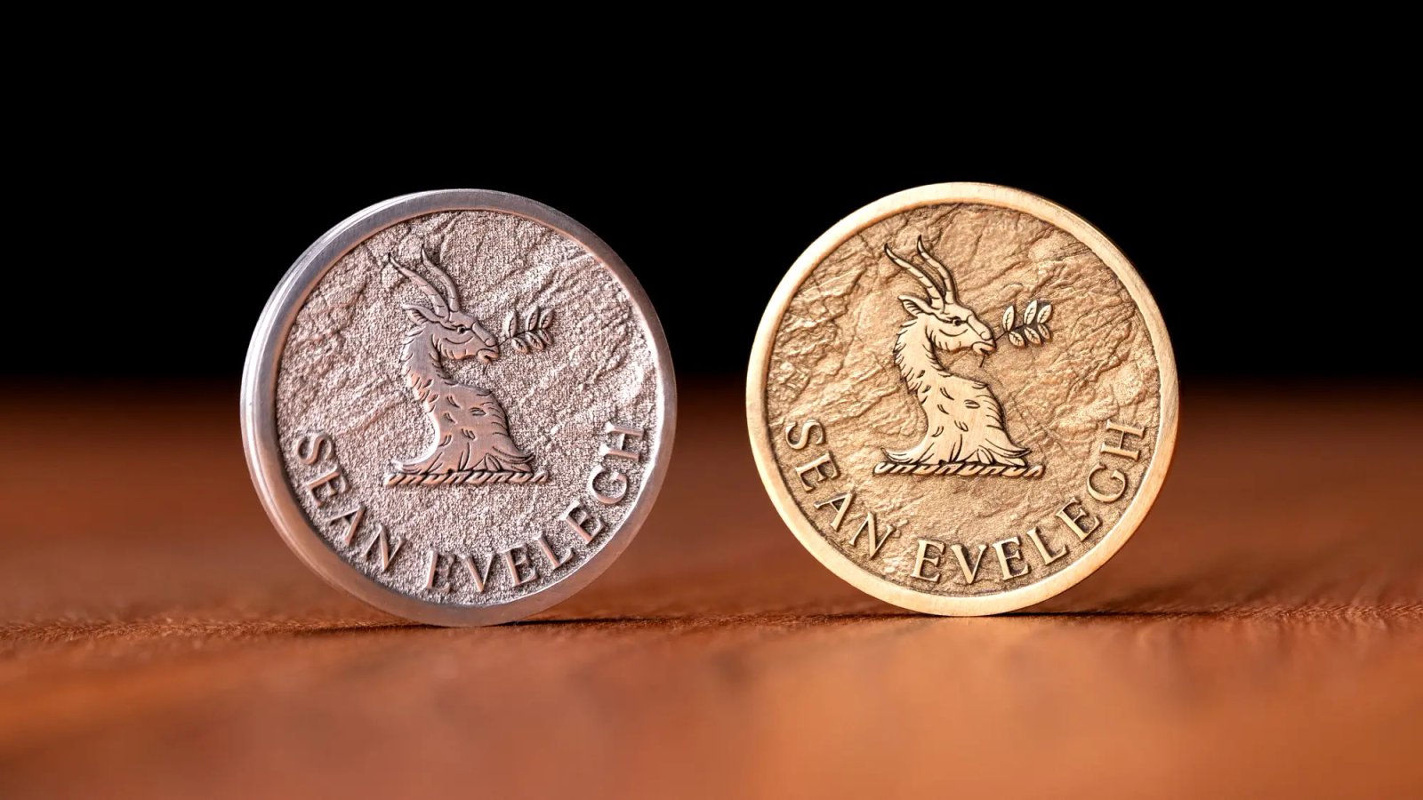 Two coins embossed with the Sean Evelegh logo