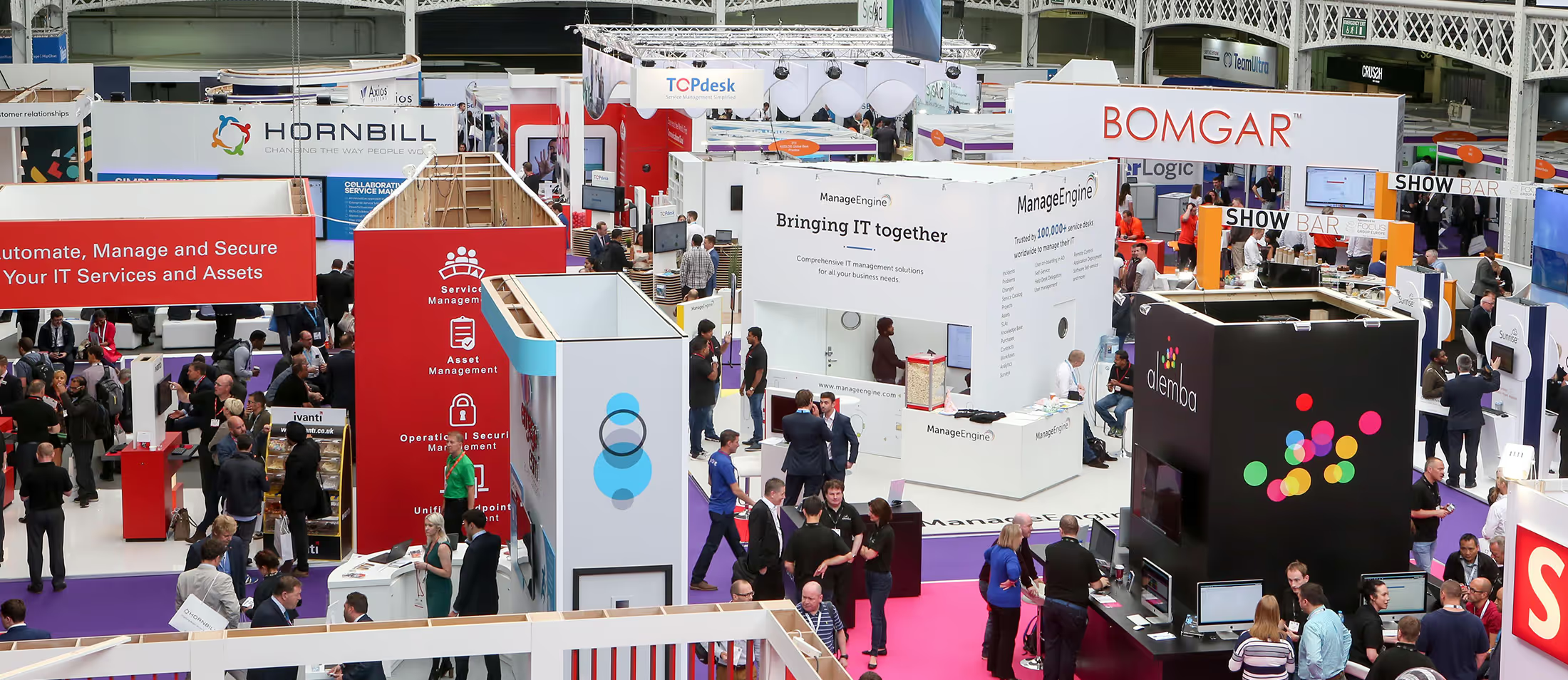 An image of a convention, a busy crowd and many tech stalls