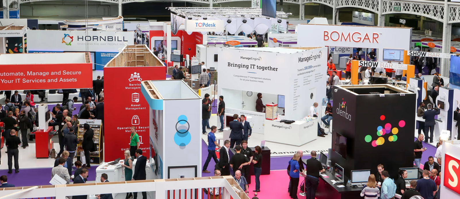 An image of a convention, a busy crowd and many tech stalls