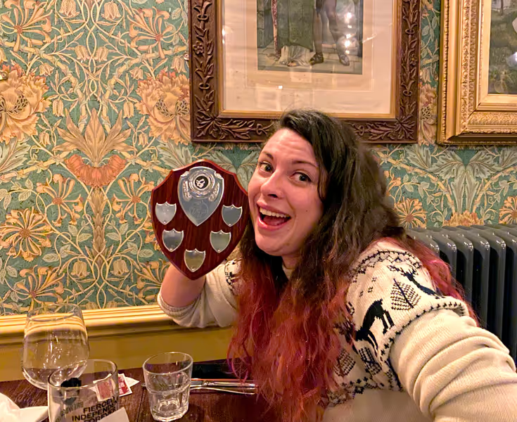 A young woman holding up a plaque