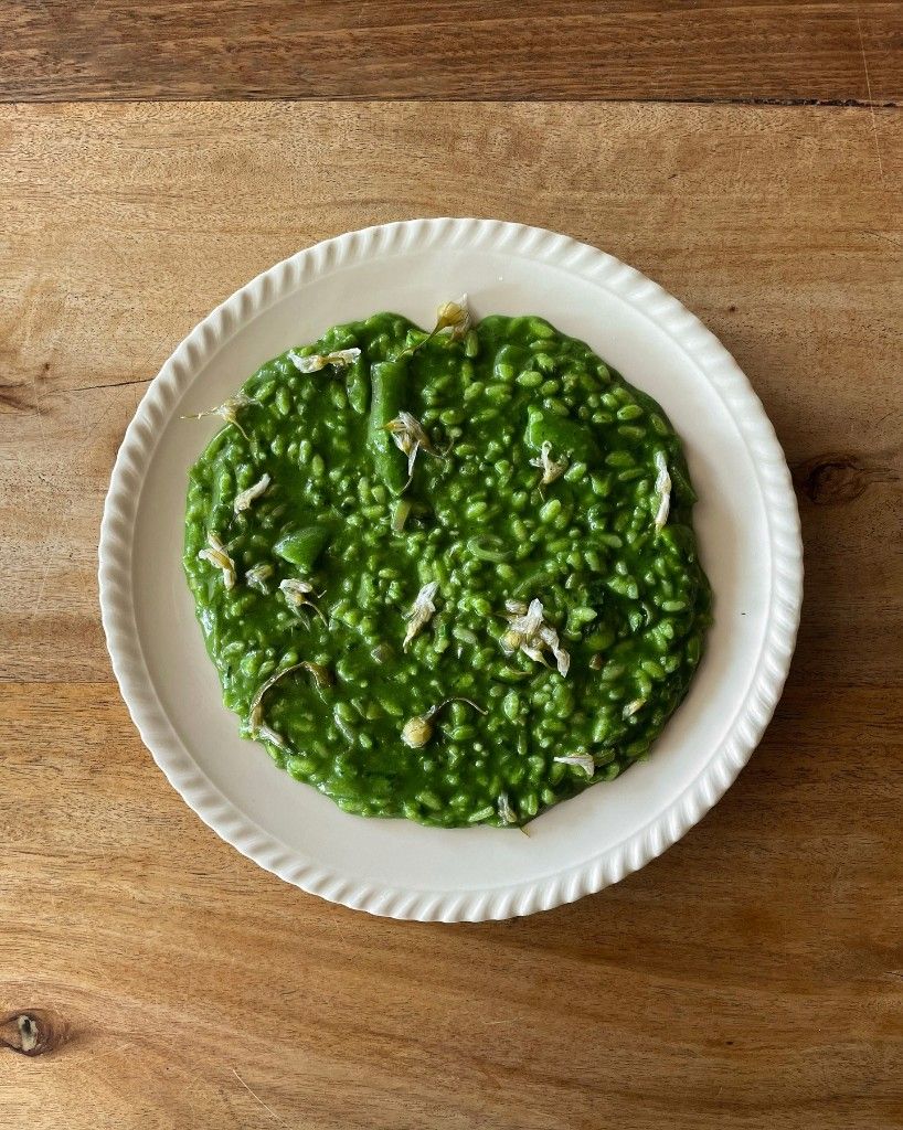 Bright green pea and herb risotto with chamomile flowers