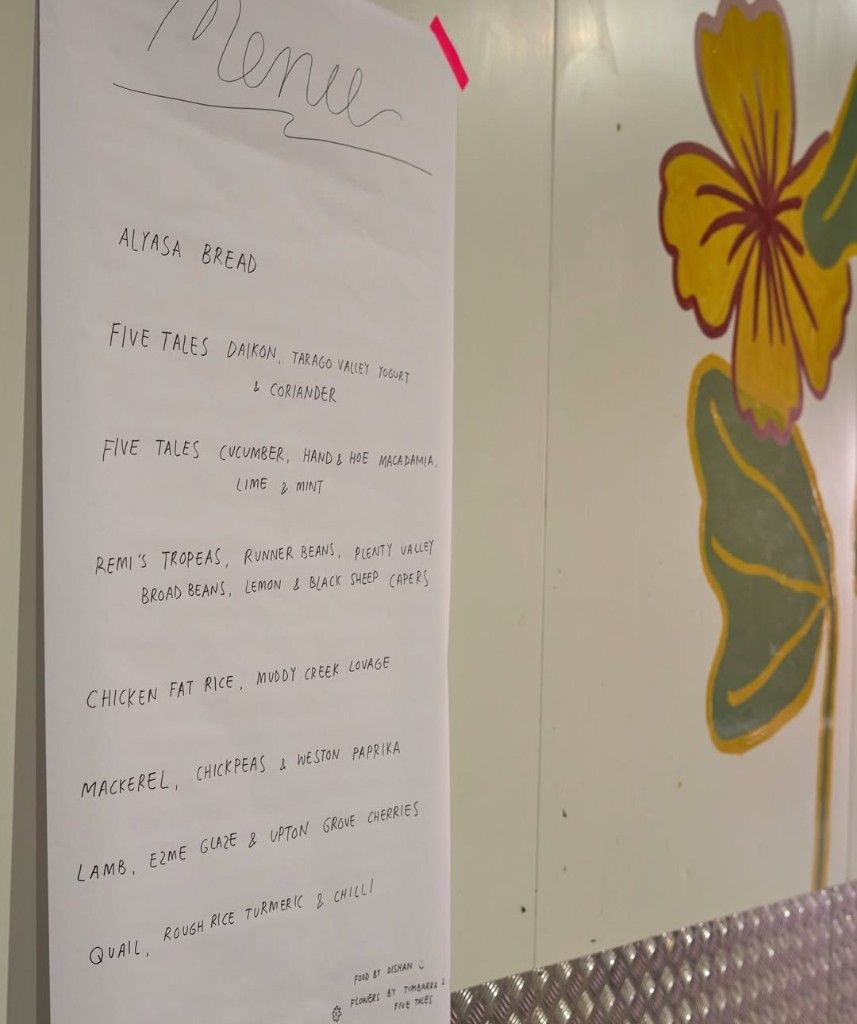 Hand-lettered menu beside a hand-painted flower for the Natoora Christmas event