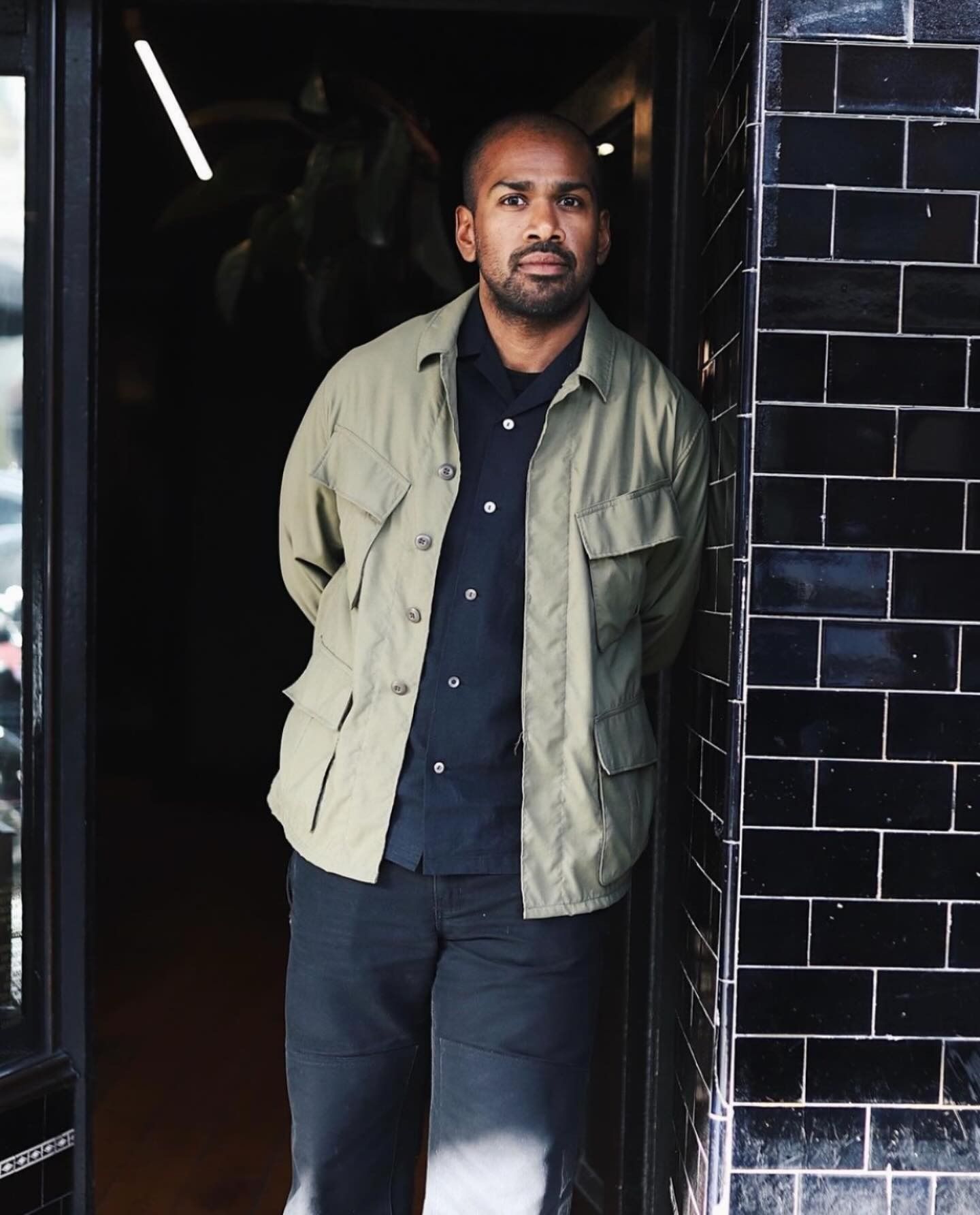 Dishan Vincent standing in a doorway framed by black glazed tiles