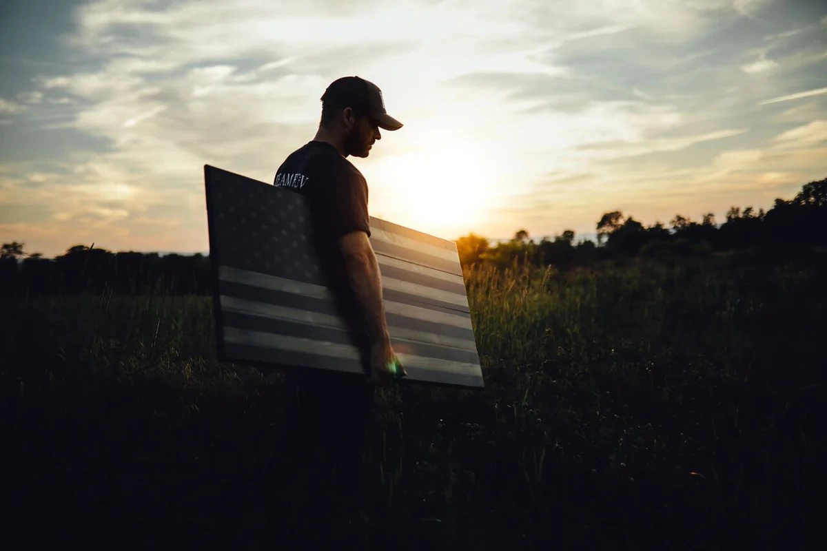 Man holding a wooden flag