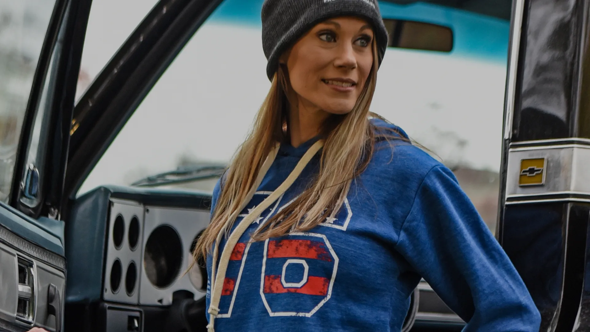 Woman wearing a hoodie exiting a truck
