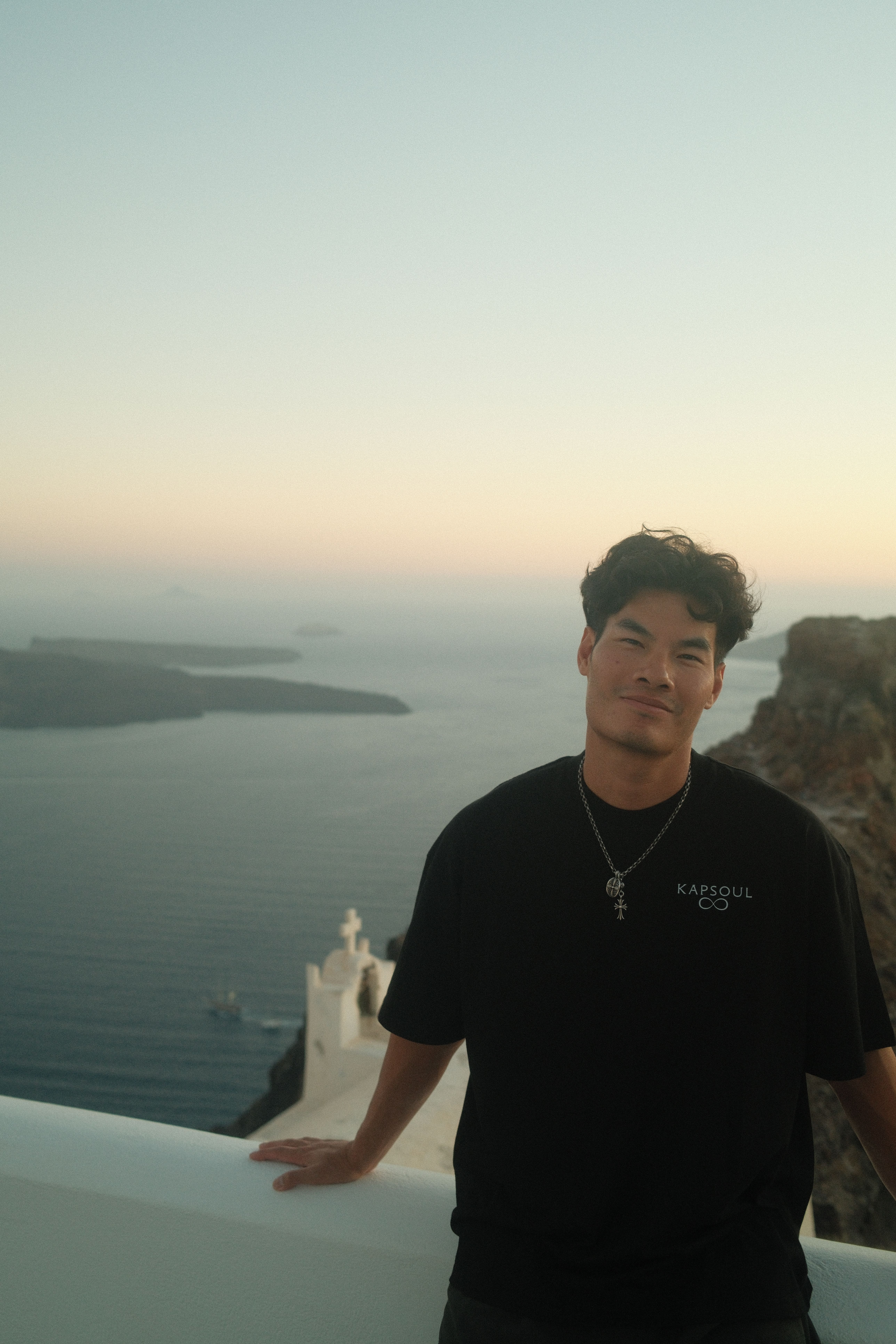  A portrait of the founder of Kapsoul, Eric Dang, against a stucco wall with shadows overlapping the shot