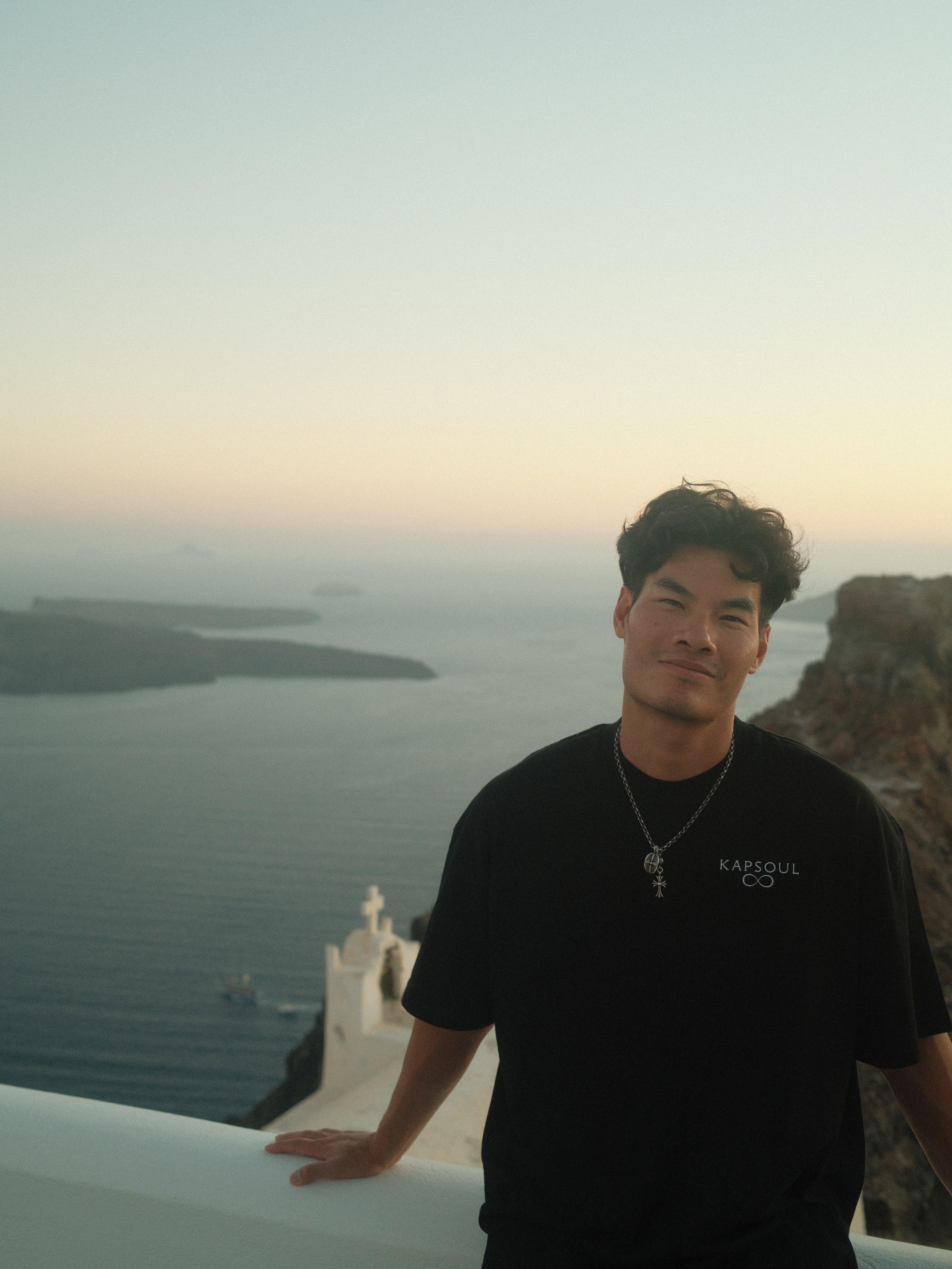 A portrait of the founder of Kapsoul, Eric Dang, against a stucco wall with shadows overlapping the shot