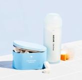 Blueland Dish Duo on white tile: 1 refillable silicone shaker and Powder Dish Soap, 1 refillable tin and dishwasher tablets